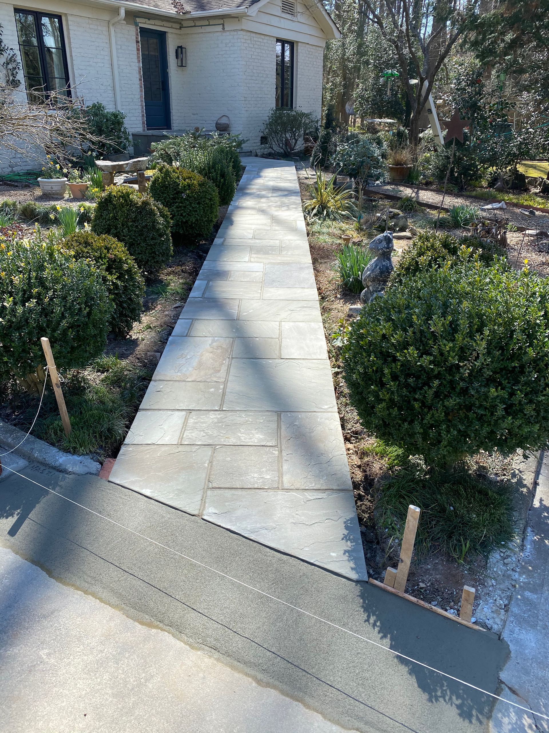 A stone walkway is being built in front of a house.