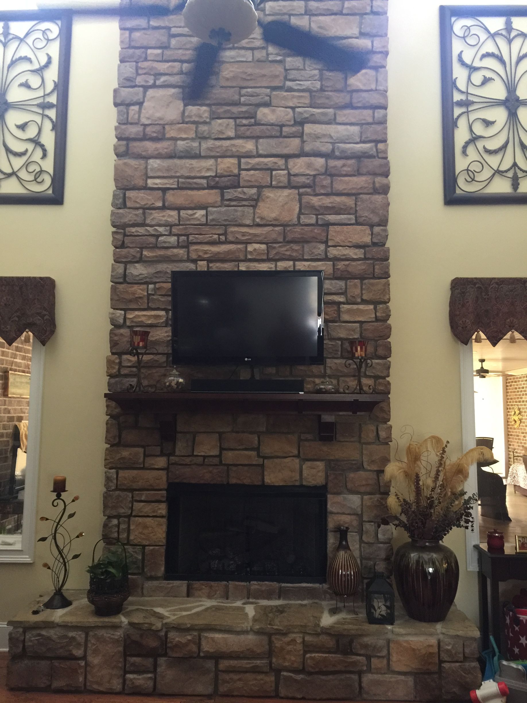 A living room with a brick fireplace and a flat screen tv