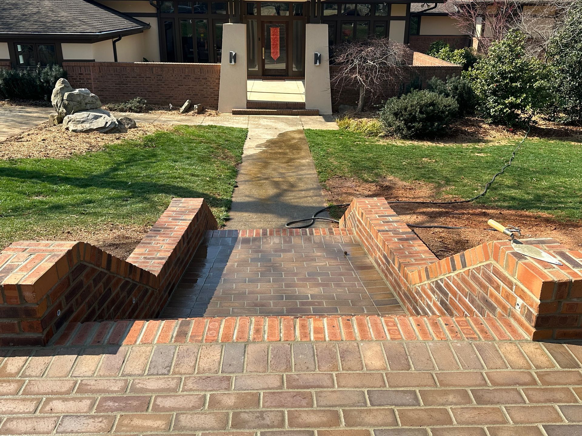 A brick walkway leading to the front door of a house.