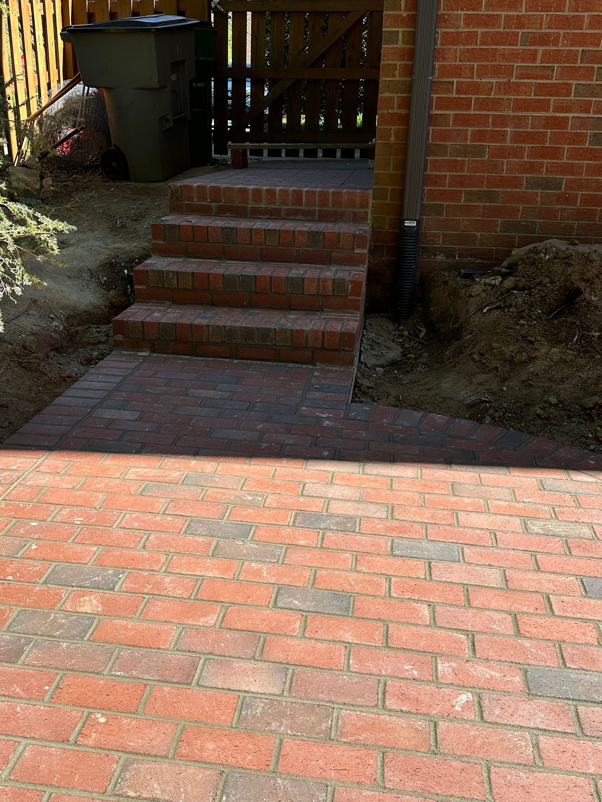A brick walkway with stairs leading up to a brick building.