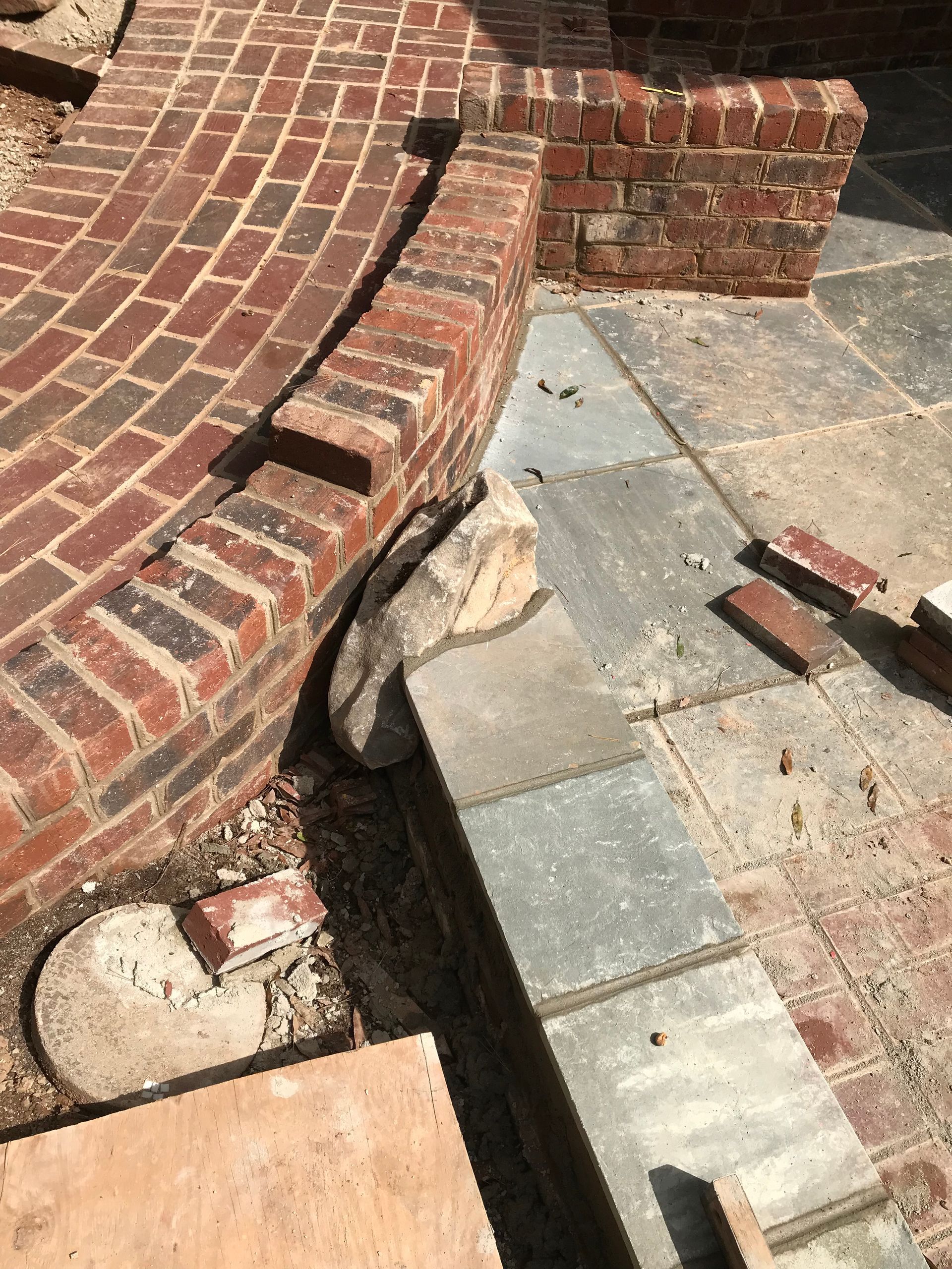 A brick walkway is being built next to a stone walkway.
