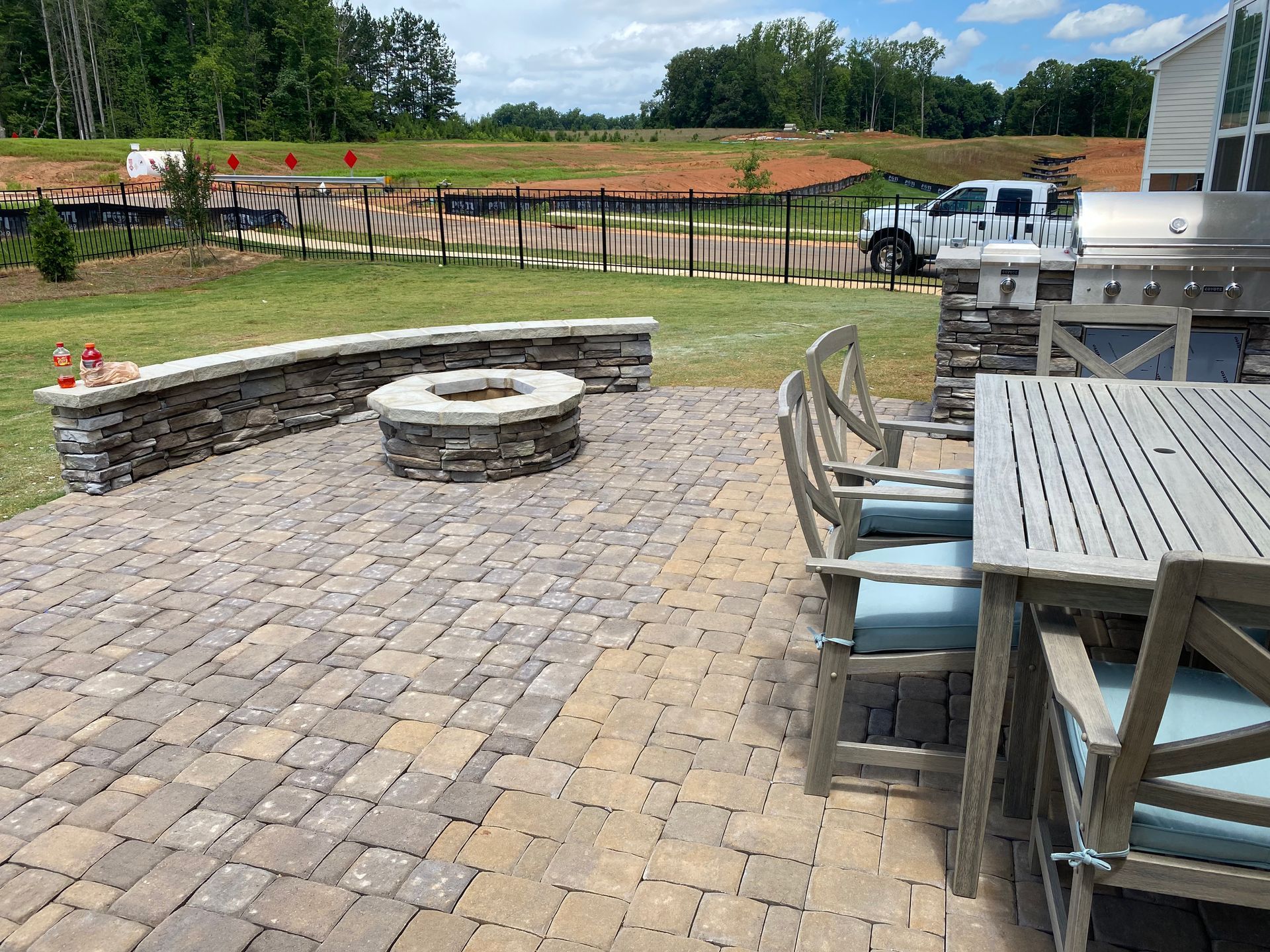 A patio with a table and chairs and a fire pit.