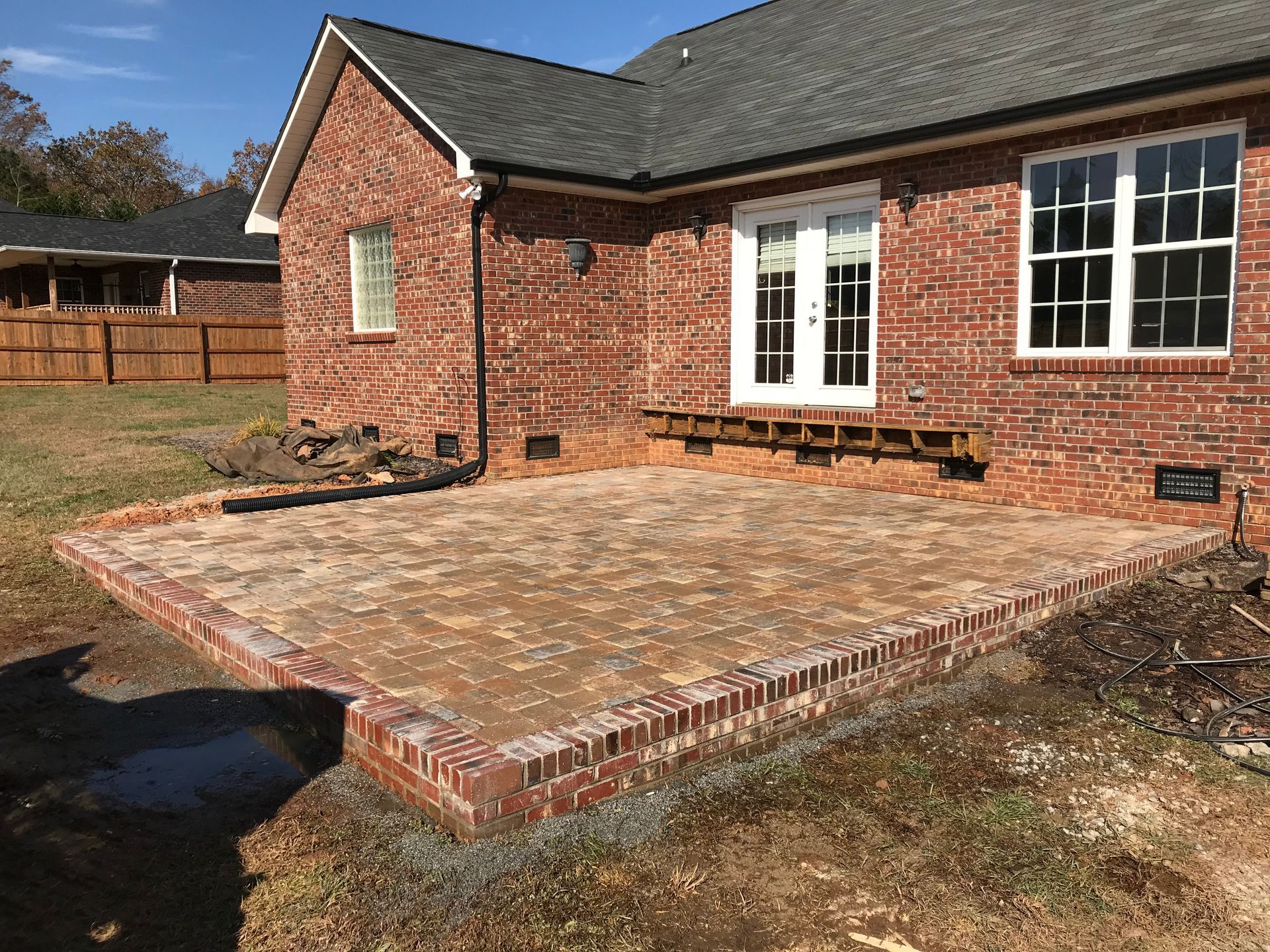 A brick house with a patio in front of it.