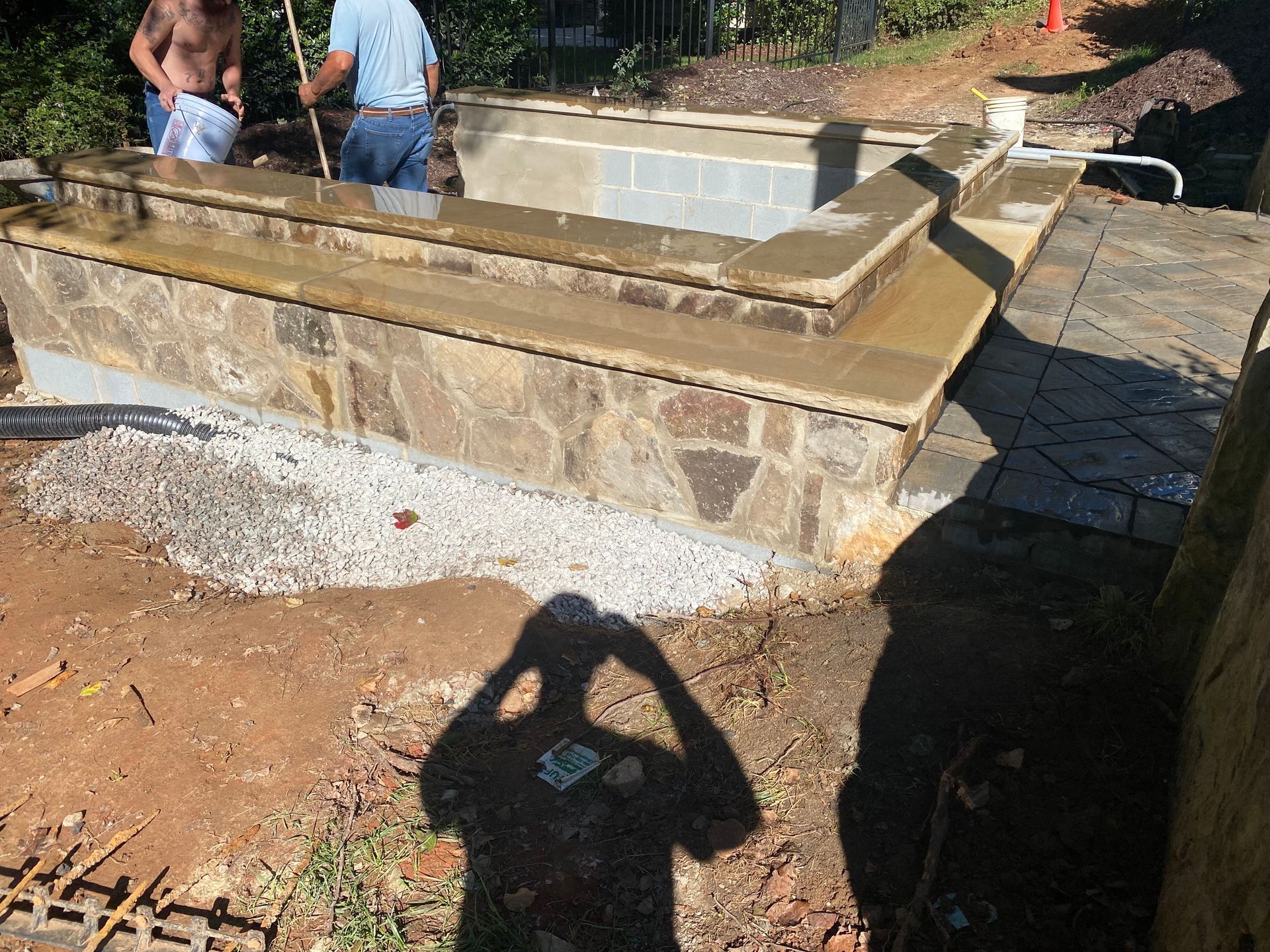 A man is standing in front of a swimming pool.