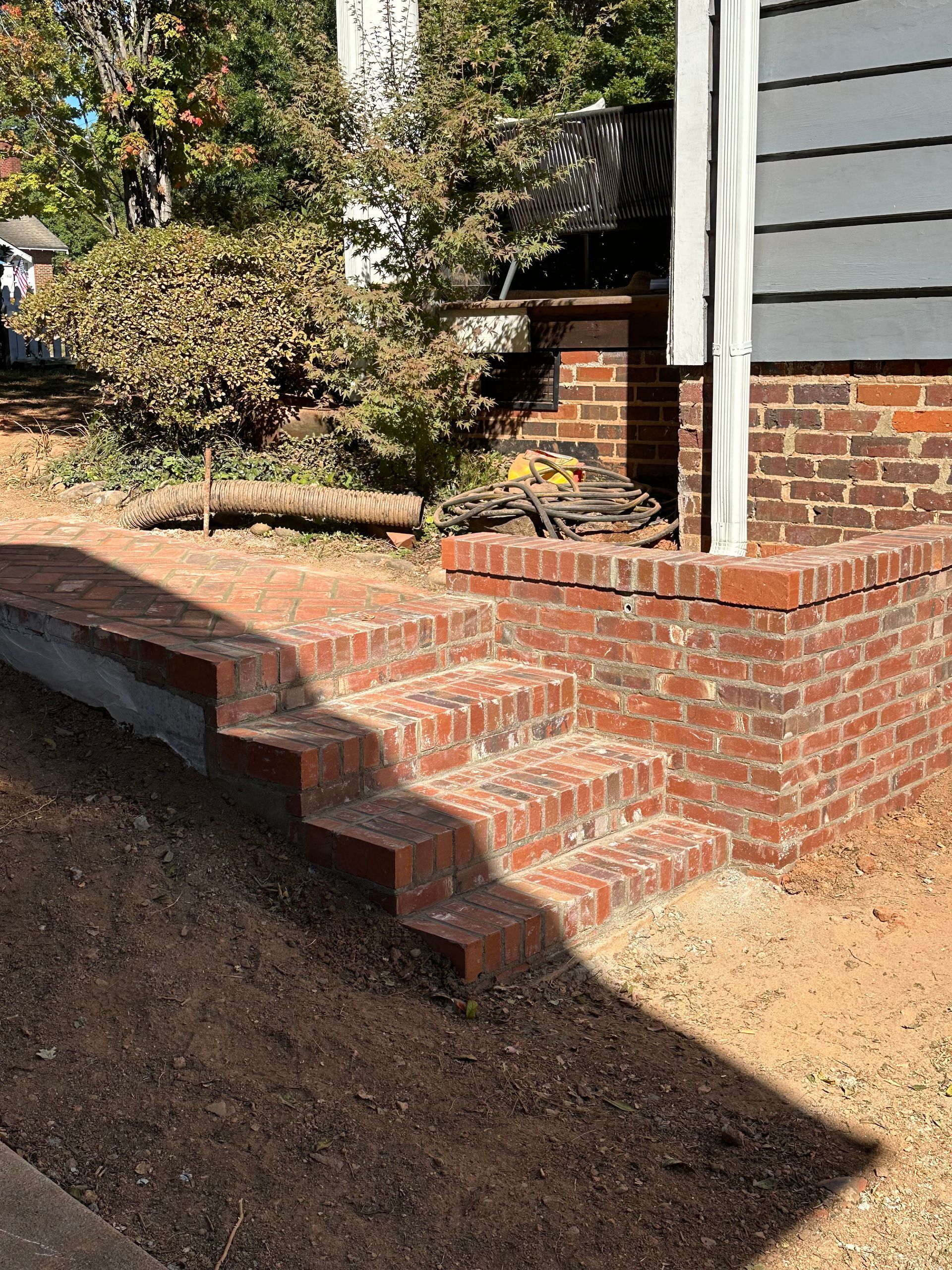 A brick porch with stairs leading up to it.