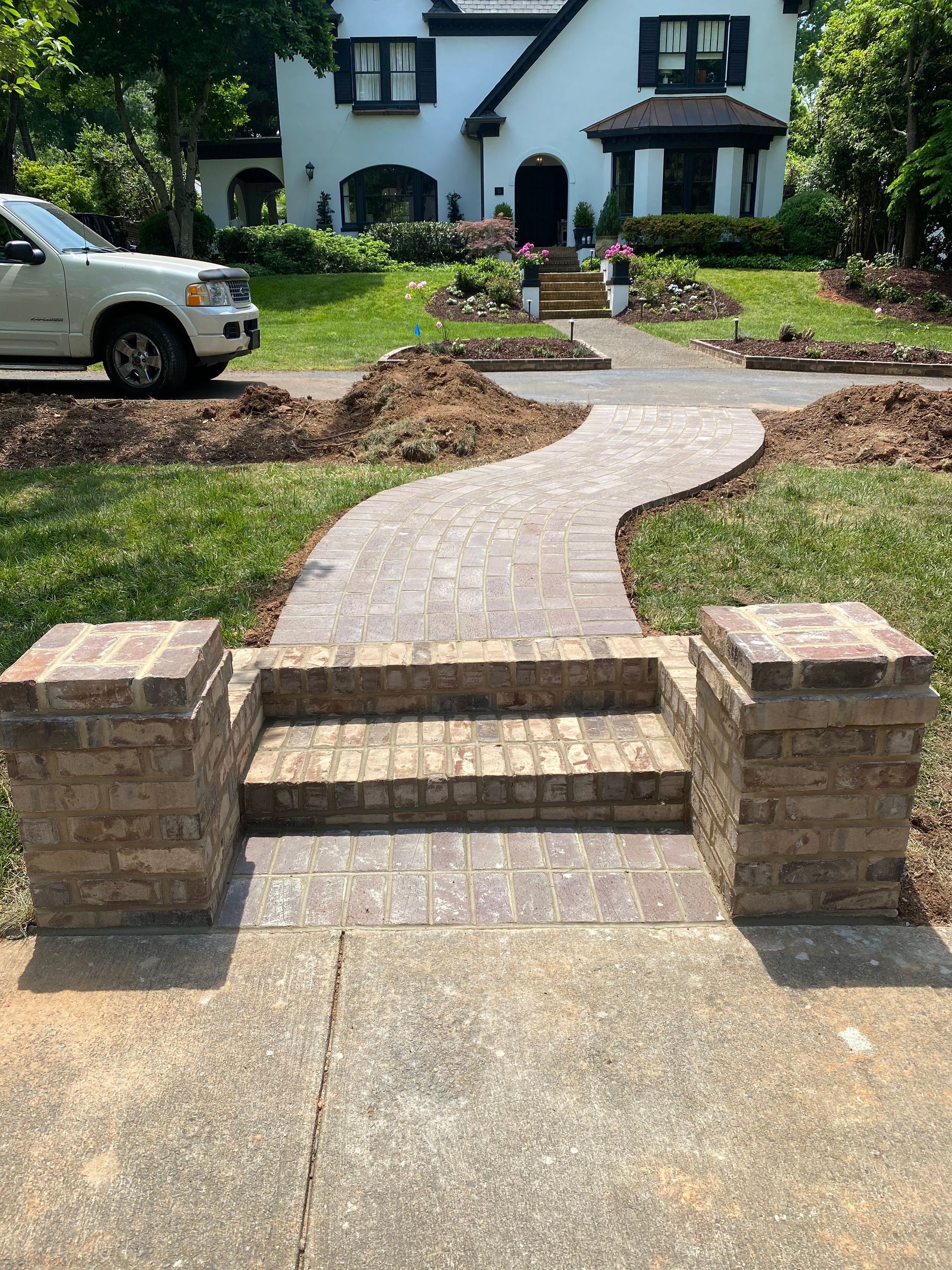 A brick walkway is being built in front of a white house.