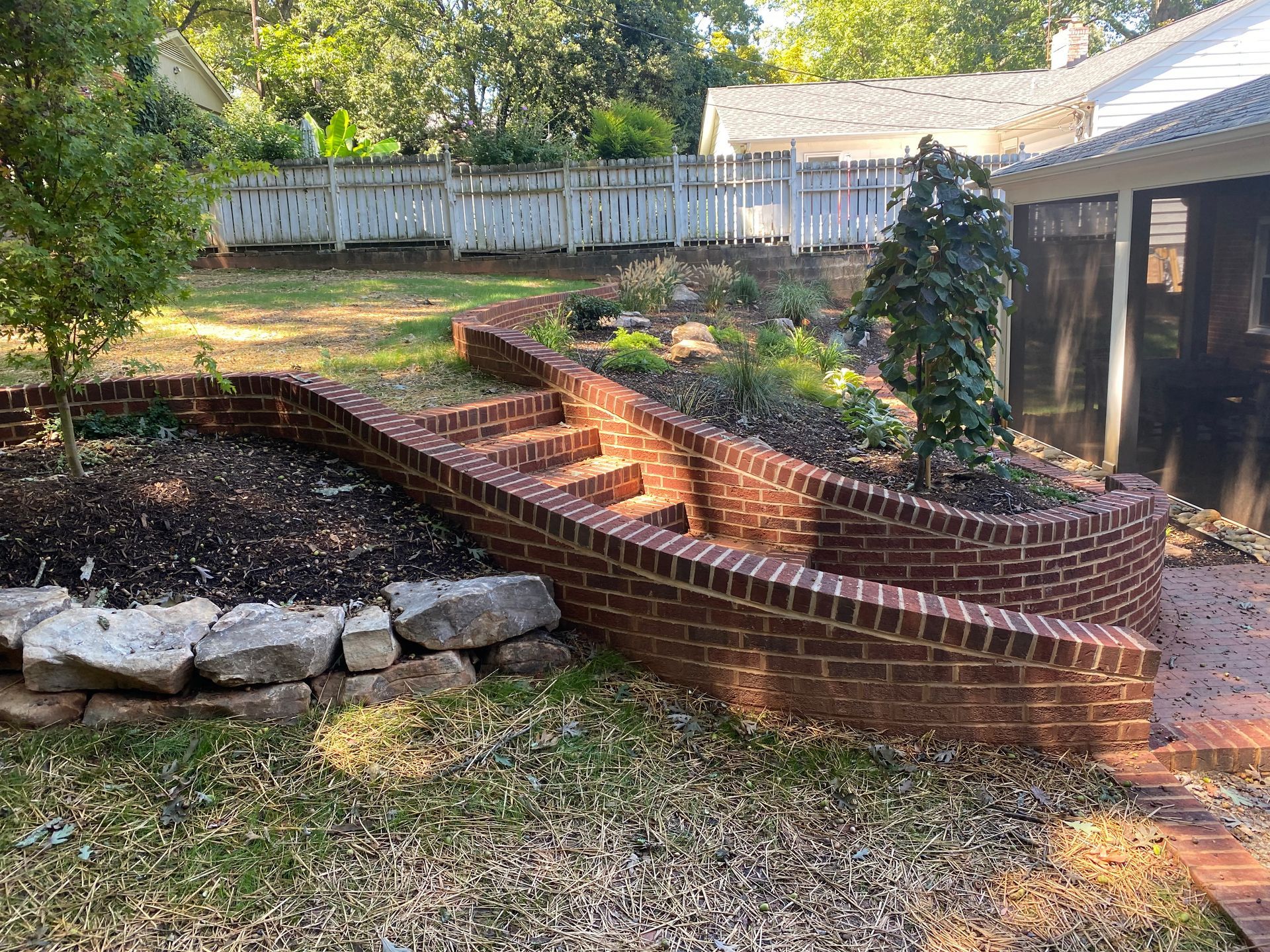 A brick wall with stairs leading up to a house.