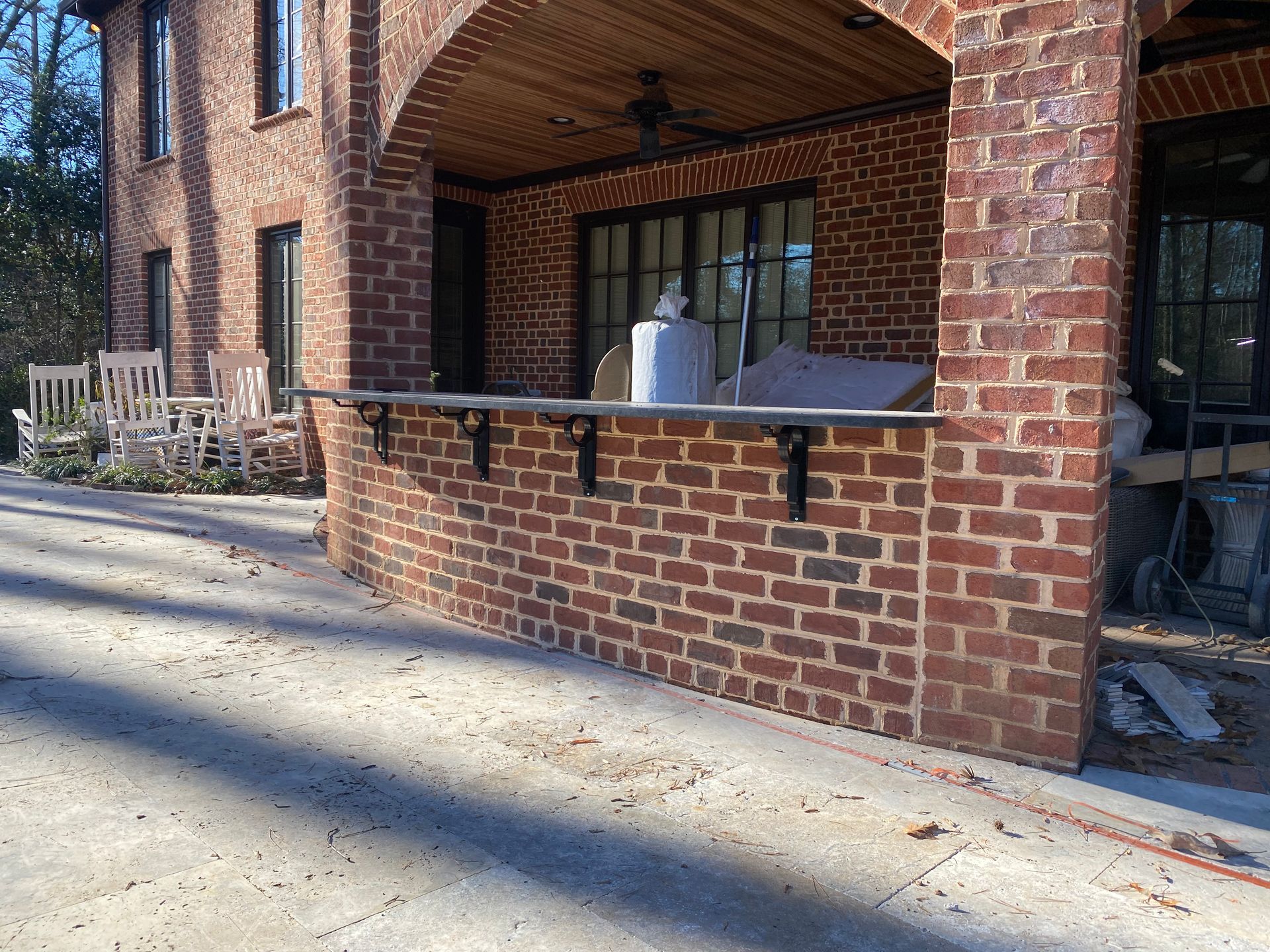 A brick building with a shelf on the side of it