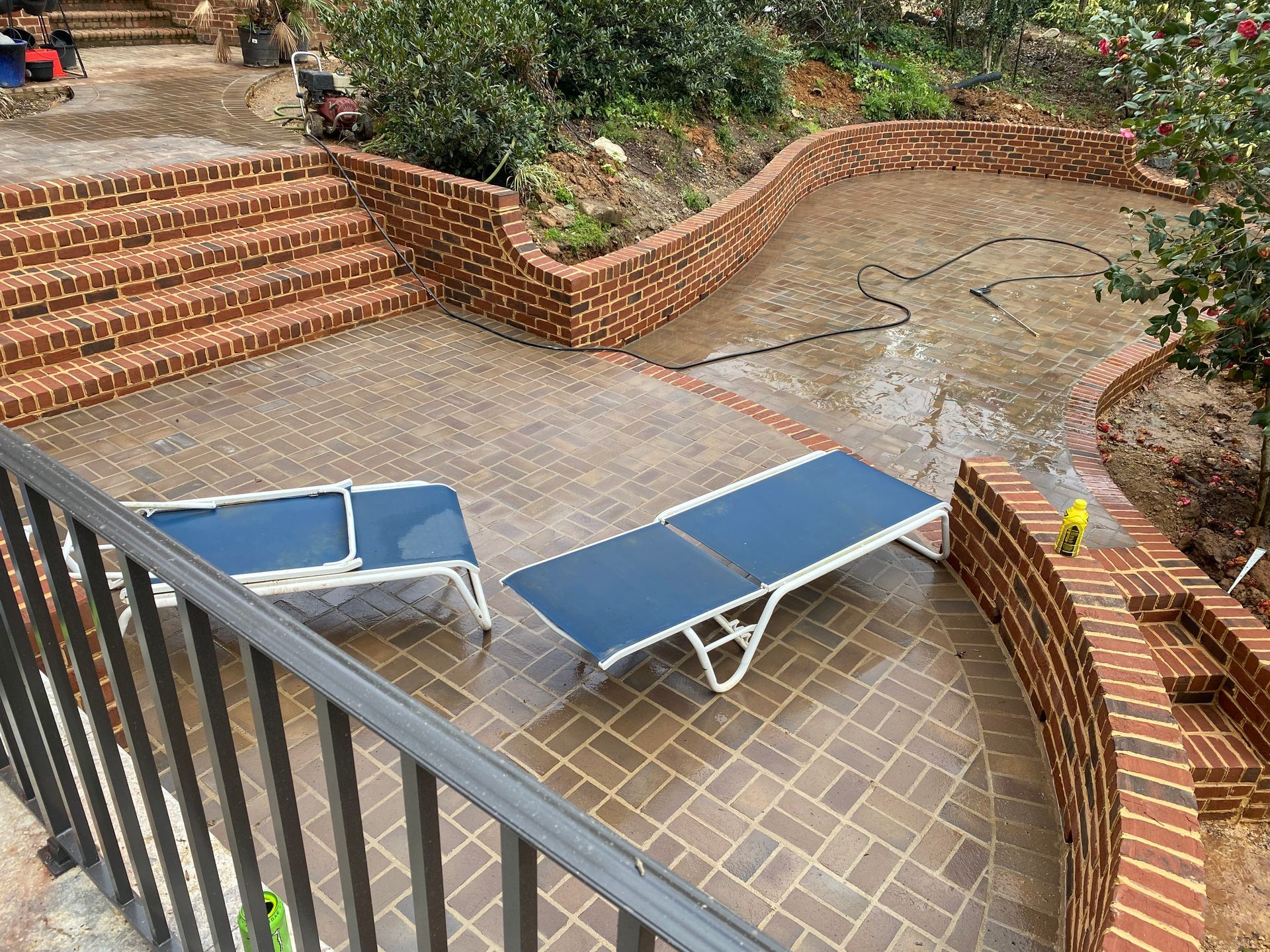 Two blue lounge chairs are sitting on a patio next to a brick wall.