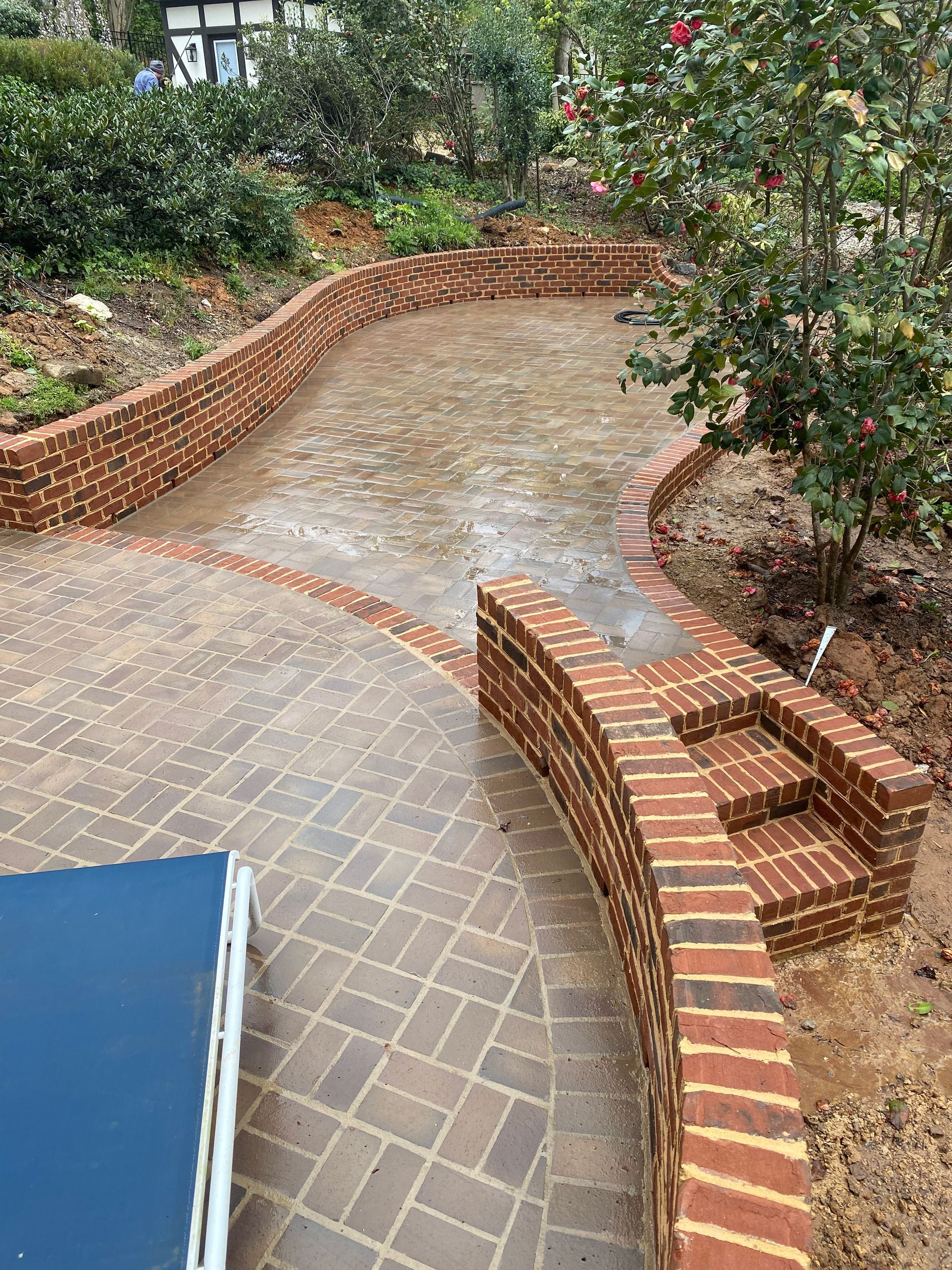 There is a brick wall in the middle of the patio.