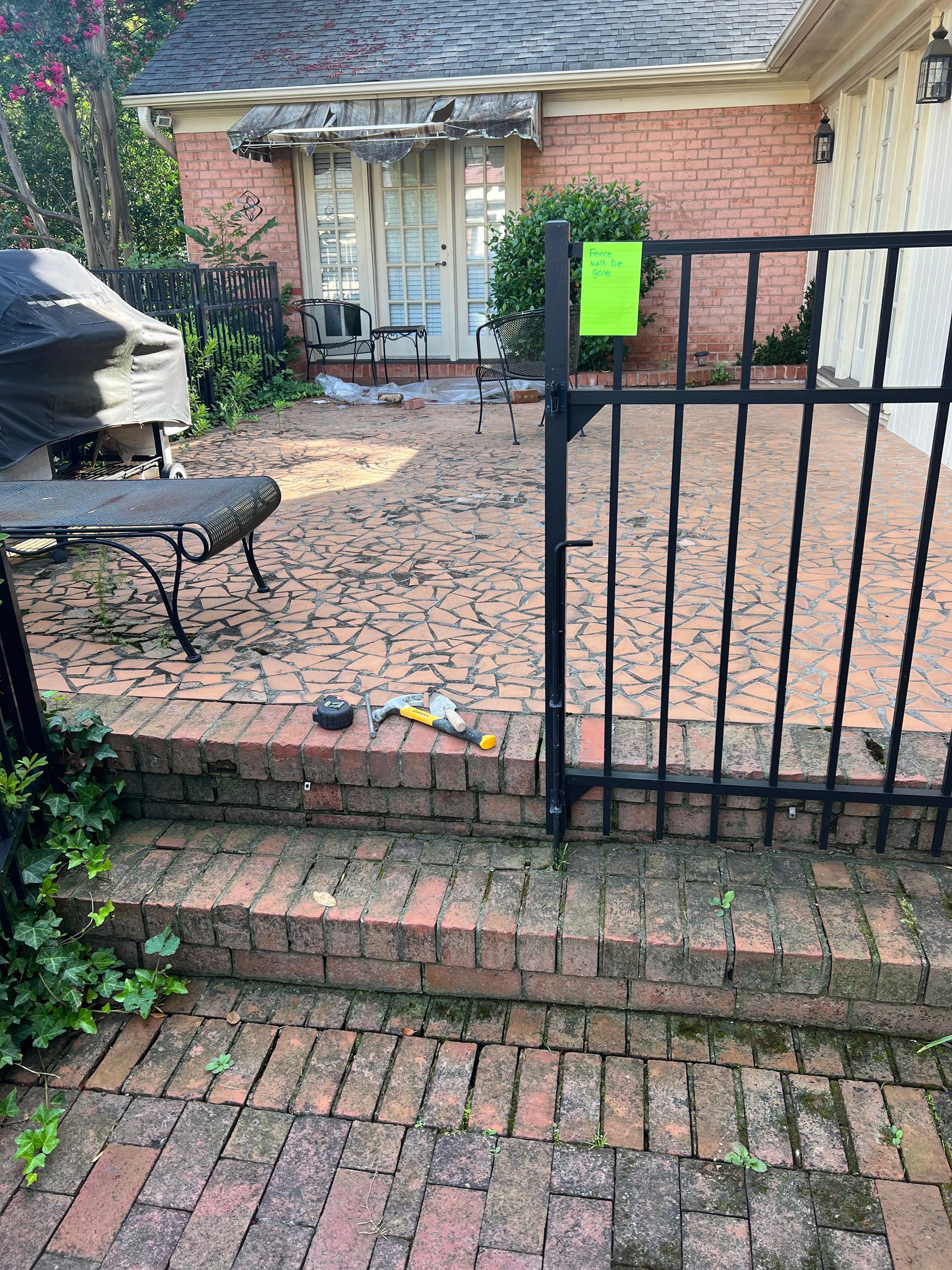 A brick walkway leading to a house with a gate
