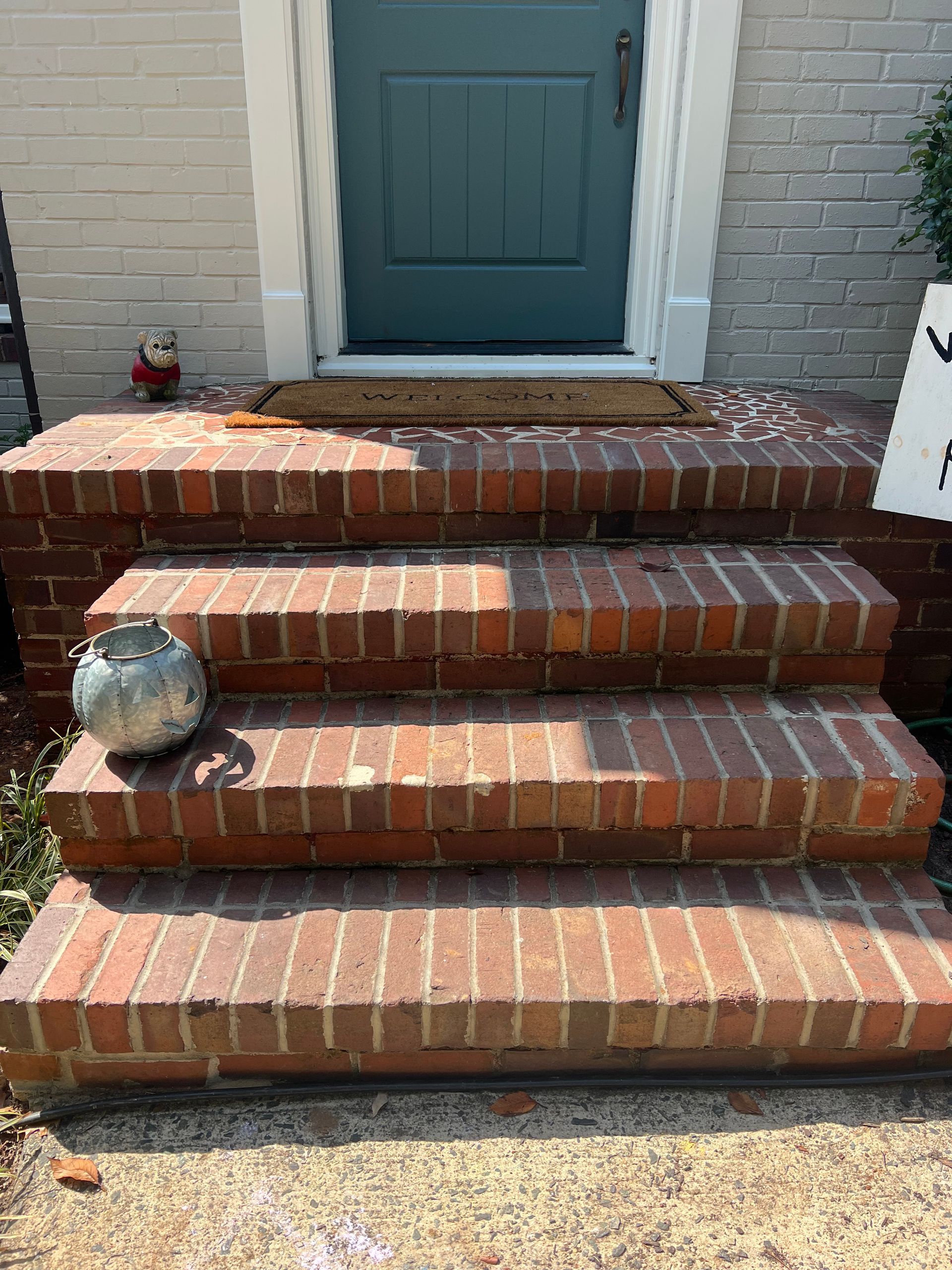A set of brick steps leading up to a front door of a house.