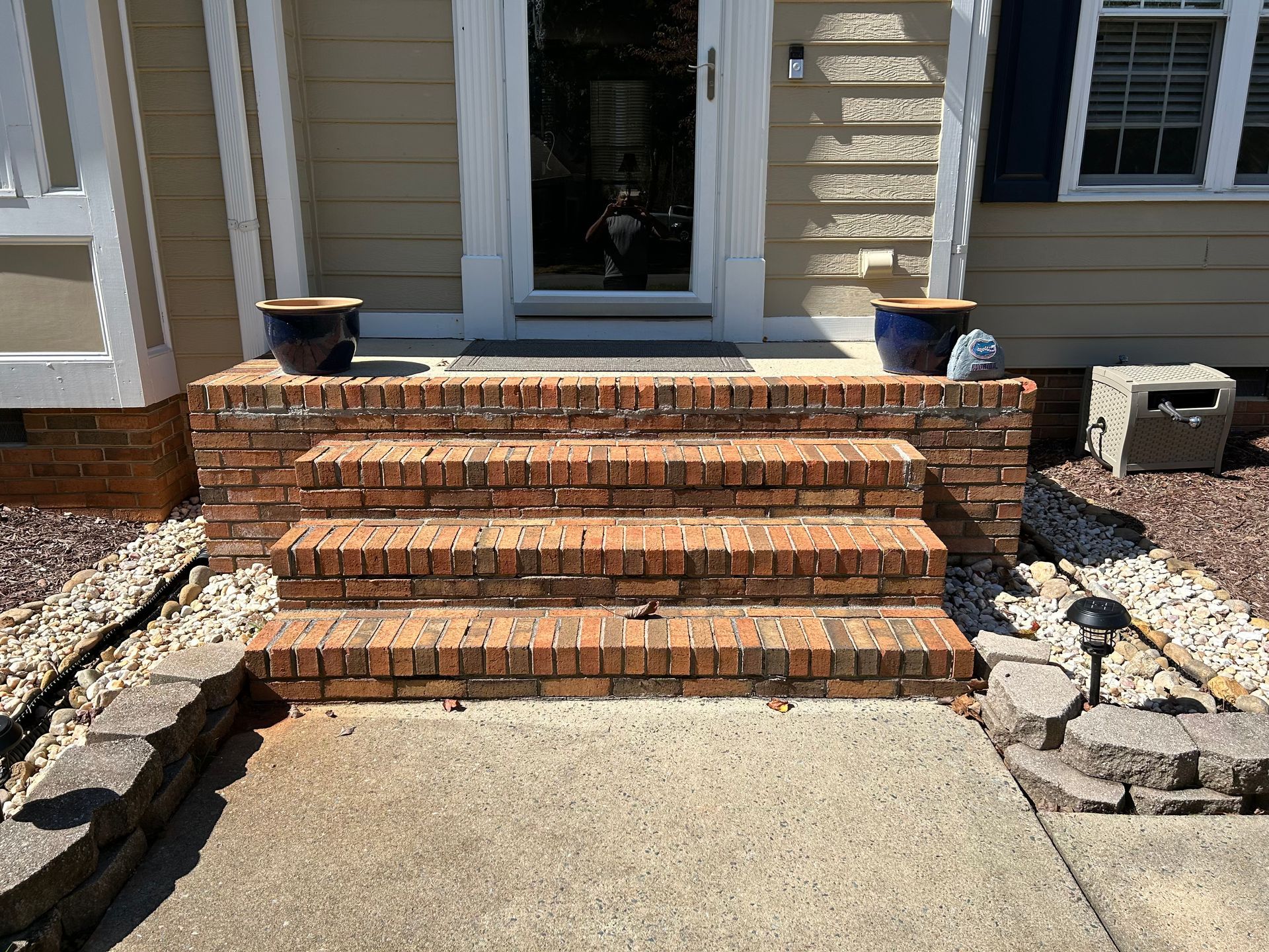 A set of brick steps leading up to the front door of a house.