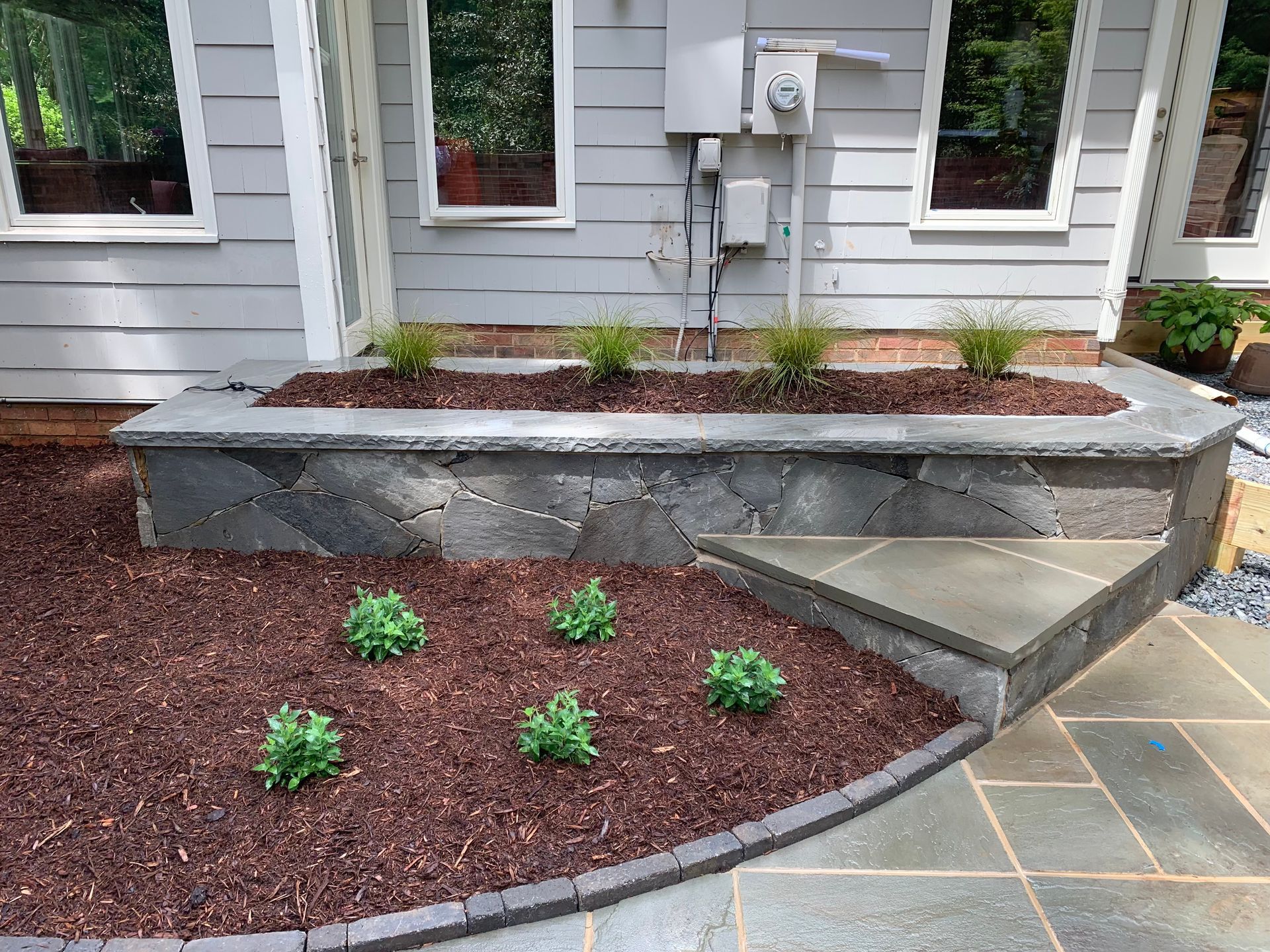 A house with a stone wall and steps in front of it