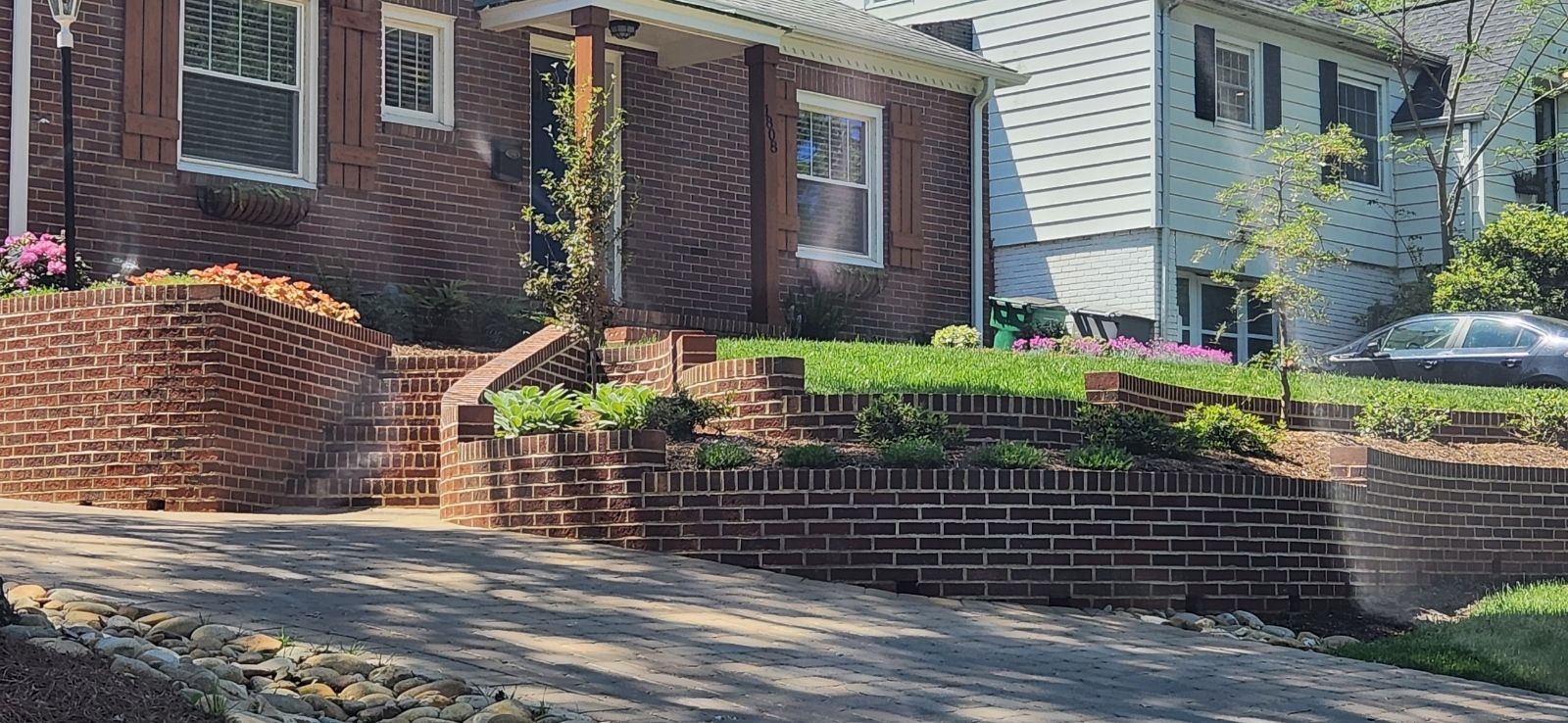 A brick house with a car parked in front of it.