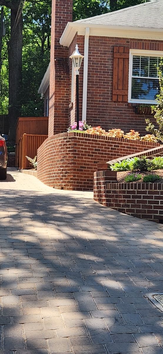 A brick house with a driveway in front of it.