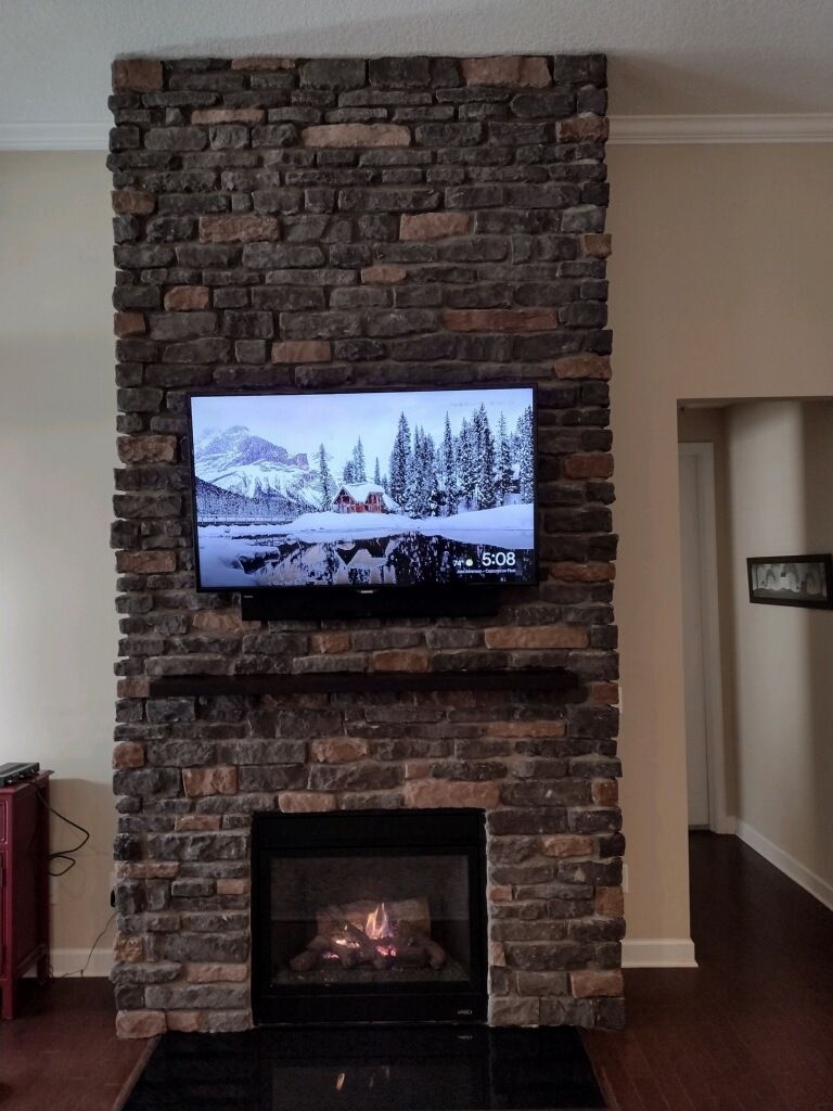 A brick fireplace with a flat screen tv above it