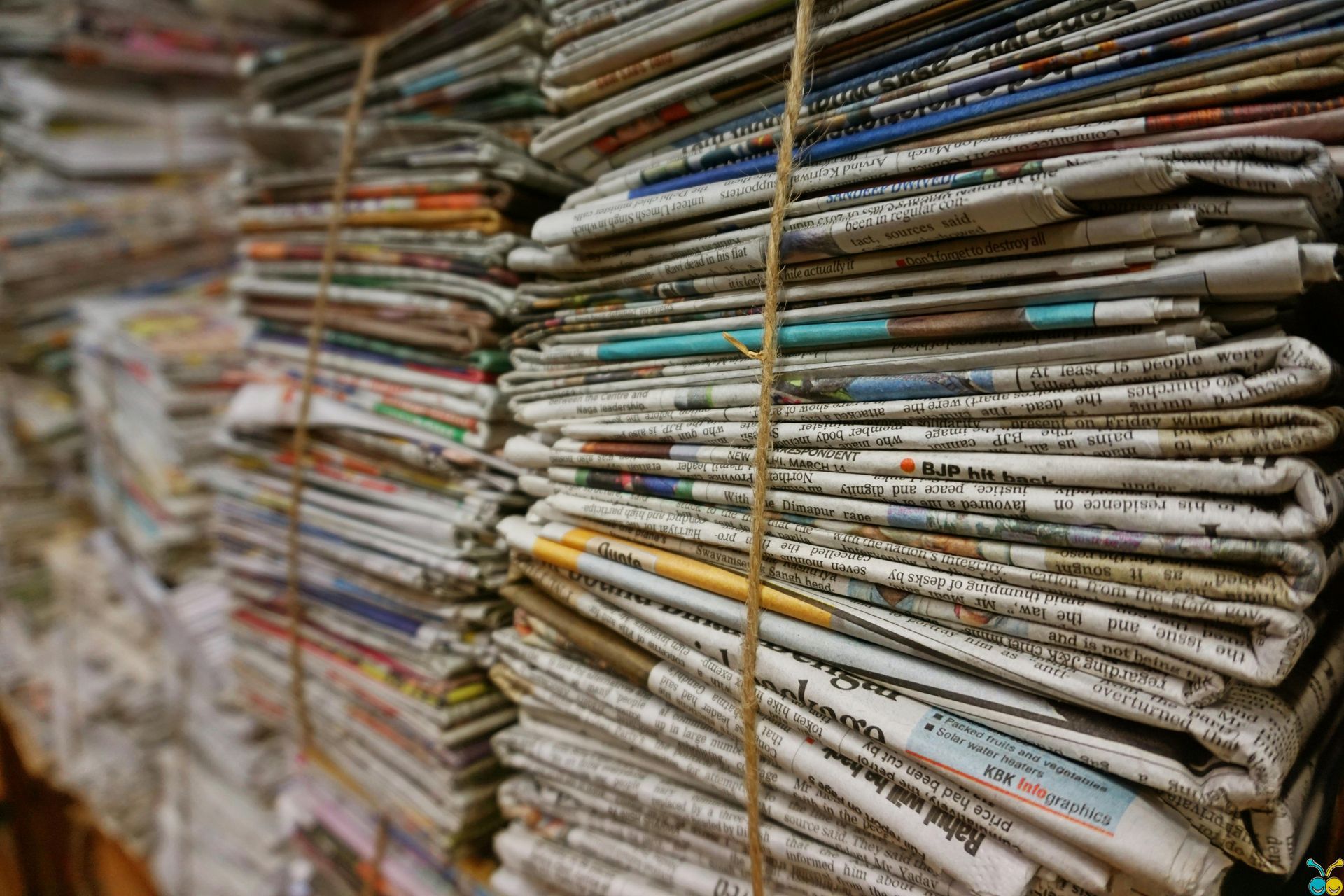 Bundled stacks of old newspapers tied with twine.