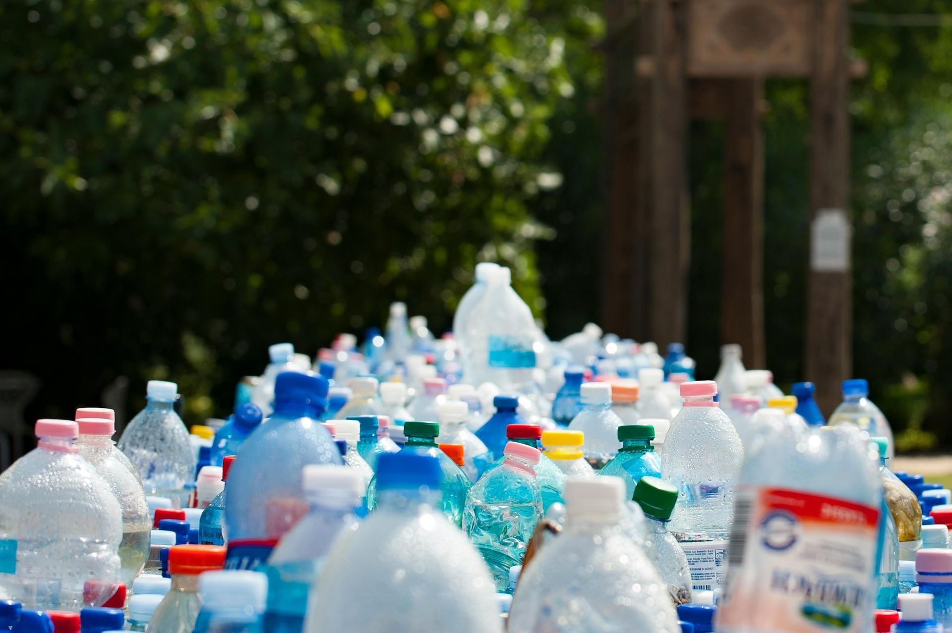 Pile of colorful plastic water bottles, outdoors.
