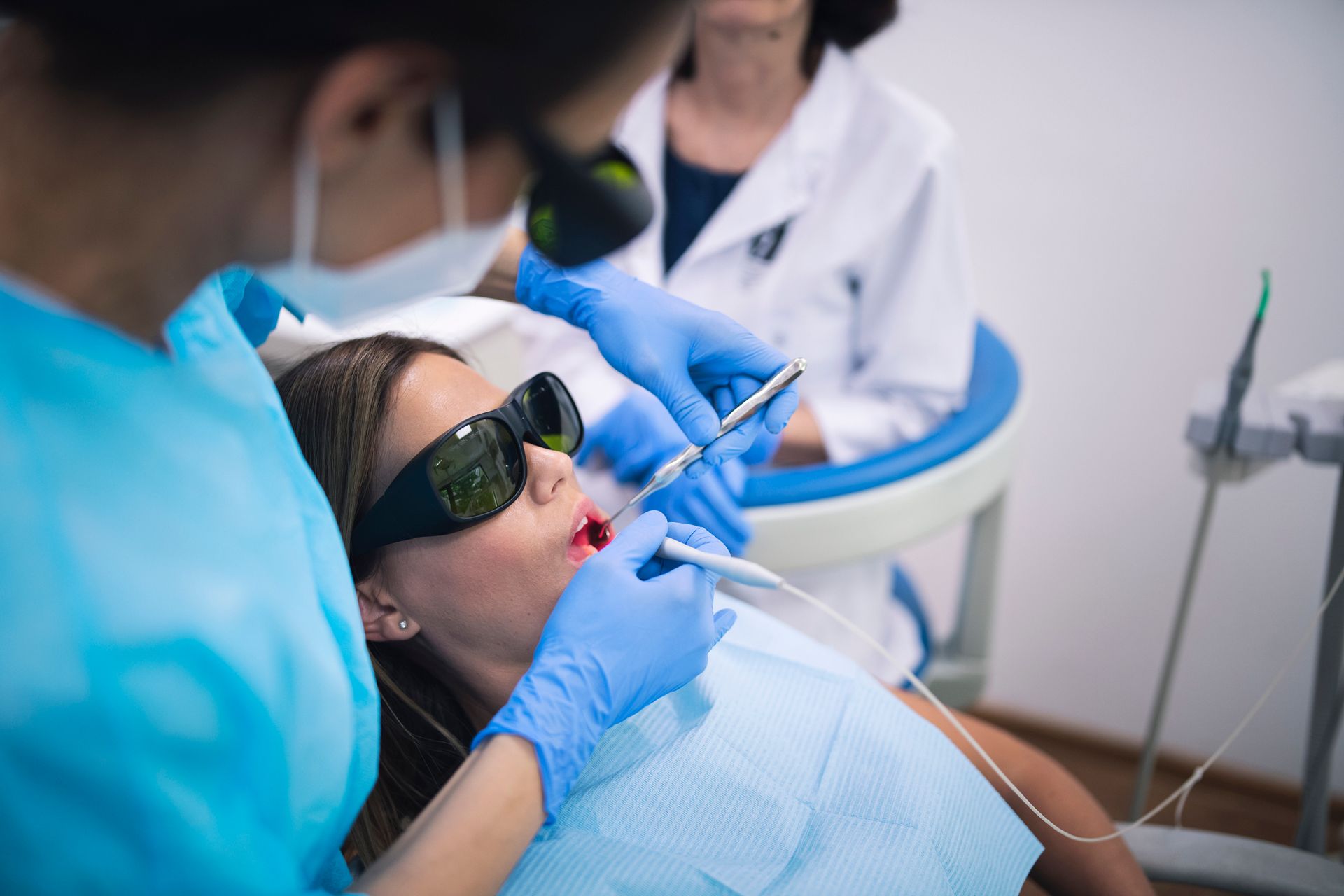 A woman is getting her teeth examined by a dentist in a dental office.