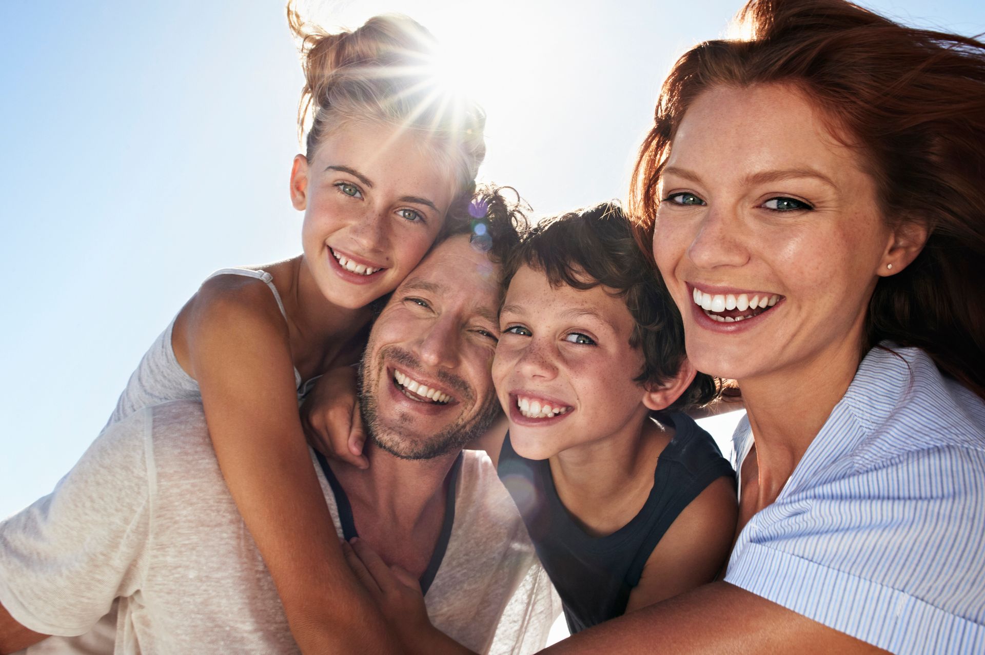 A family is posing for a picture together and smiling for the camera.