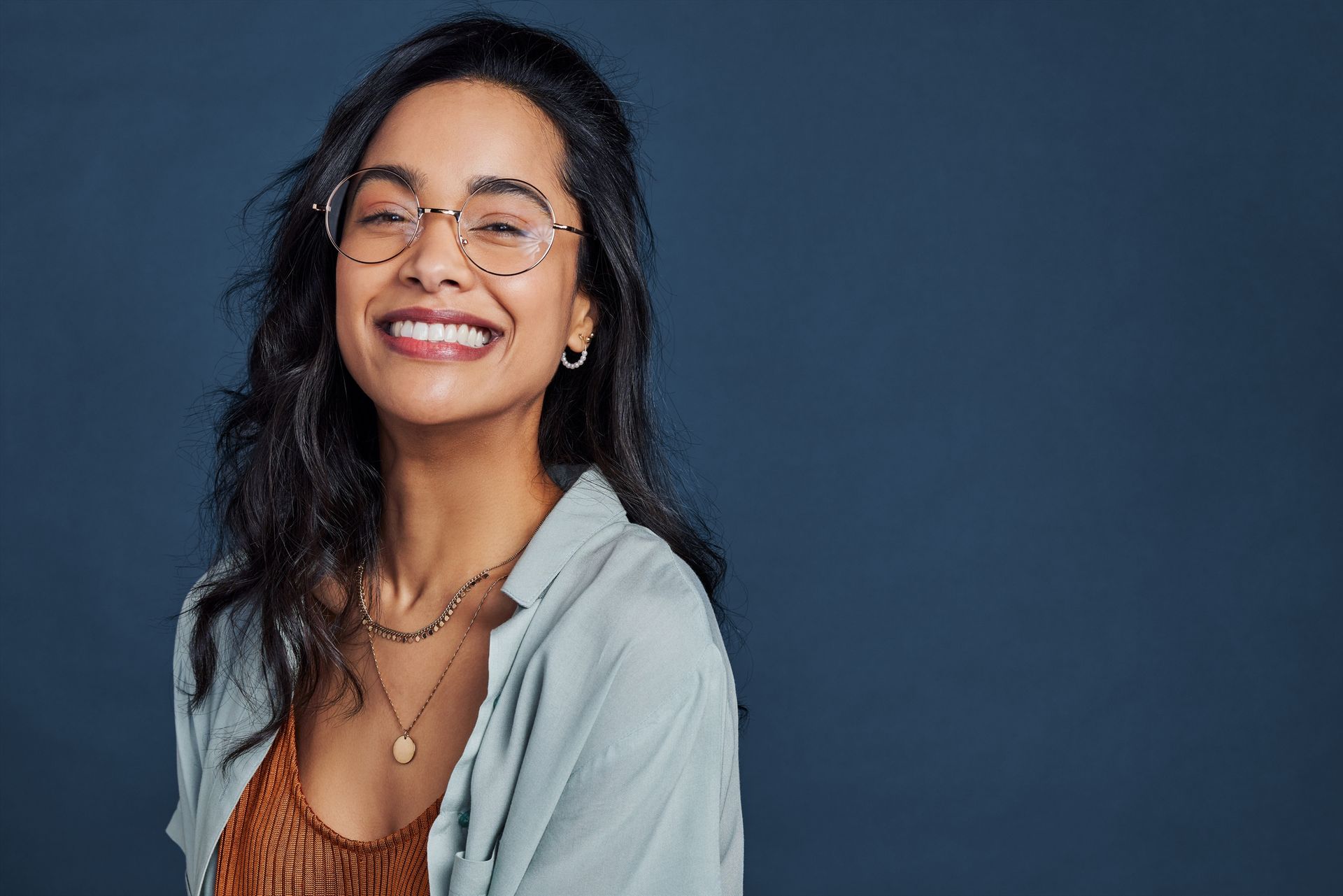 A woman wearing glasses and smiling.