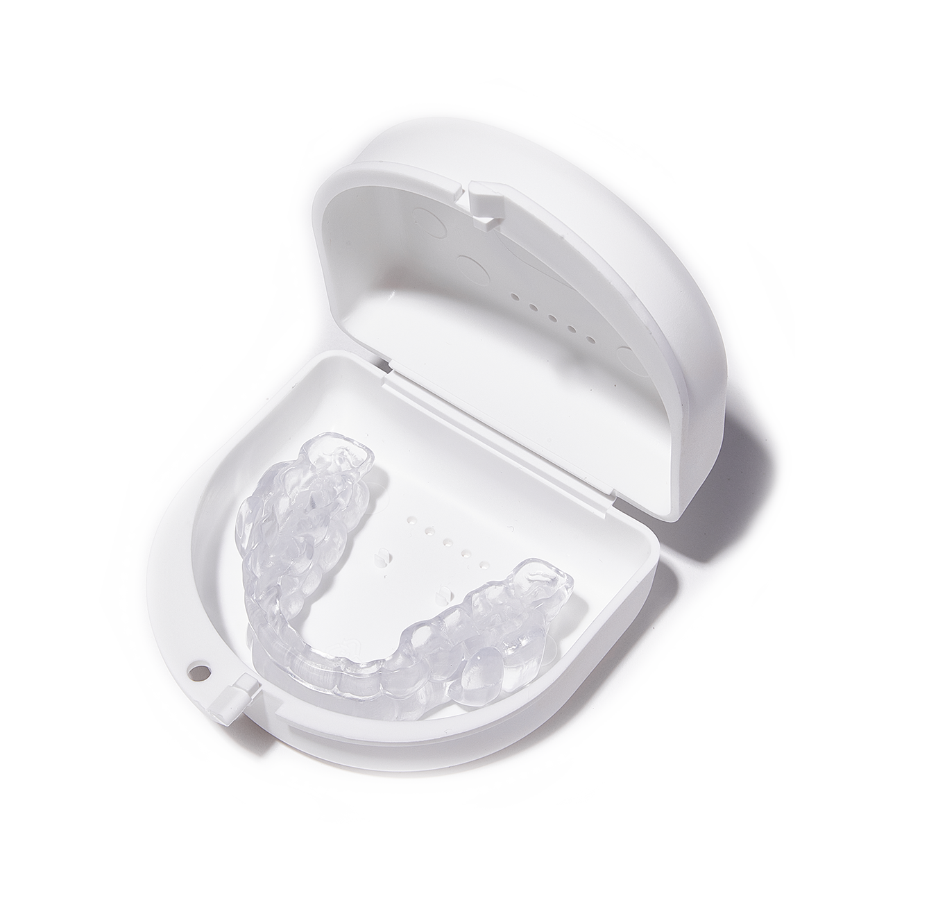 A clear mouth guard in a white case on a white background