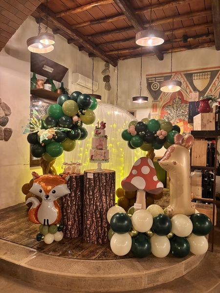 Una stanza decorata con palloncini e una torta per il primo compleanno di un bambino.