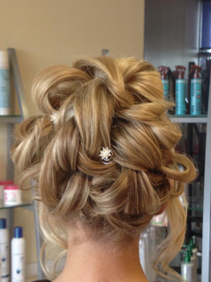The back of a woman 's head with a bun and a pearl in her hair.