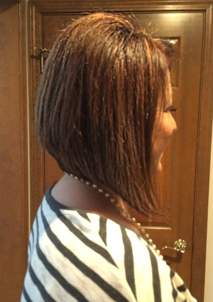 A woman with short brown hair is wearing a striped shirt