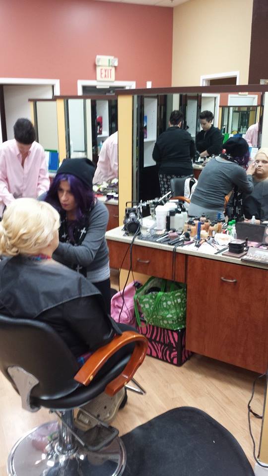 A woman with purple hair is getting her hair done in a salon.