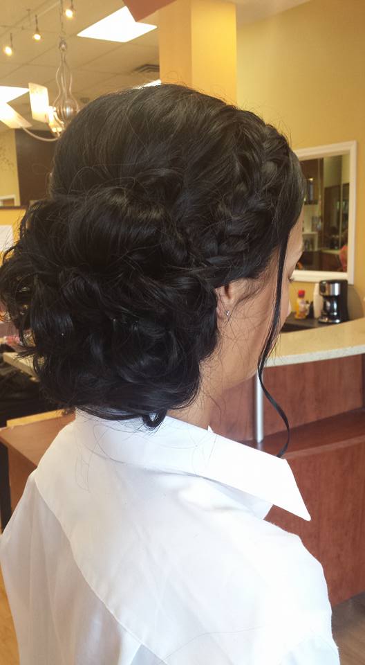 A woman in a white shirt has her hair in a bun