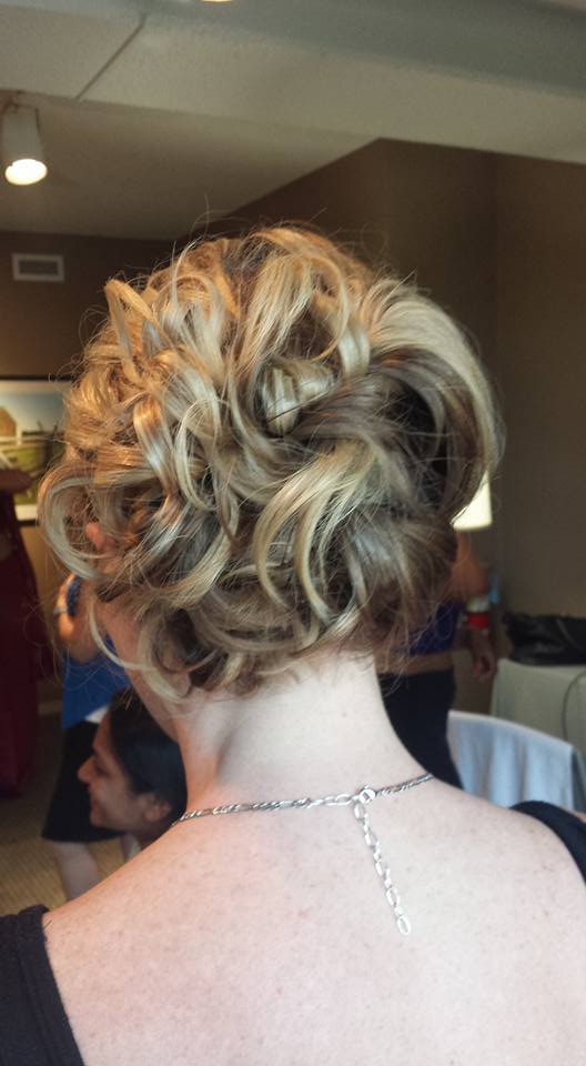The back of a woman wearing a necklace and a bun.