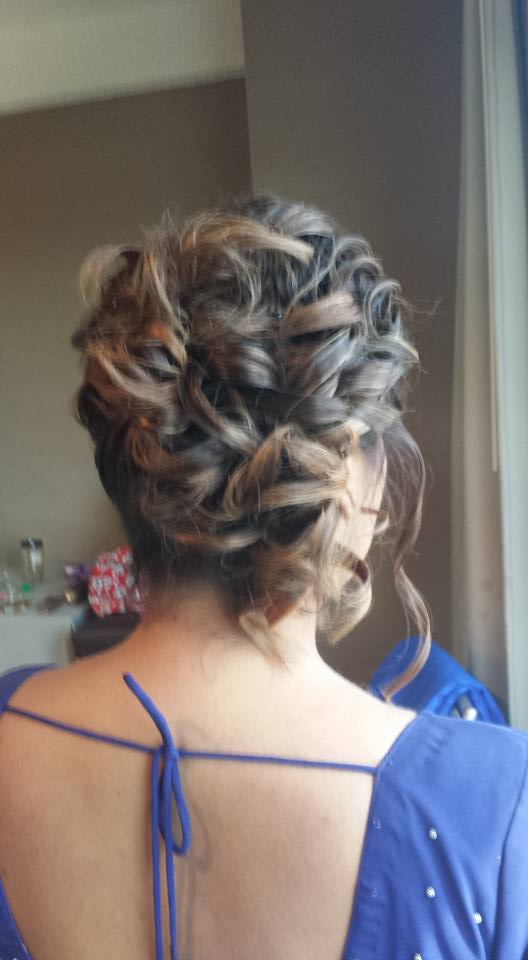 The back of a woman wearing a blue shirt and a braided bun.