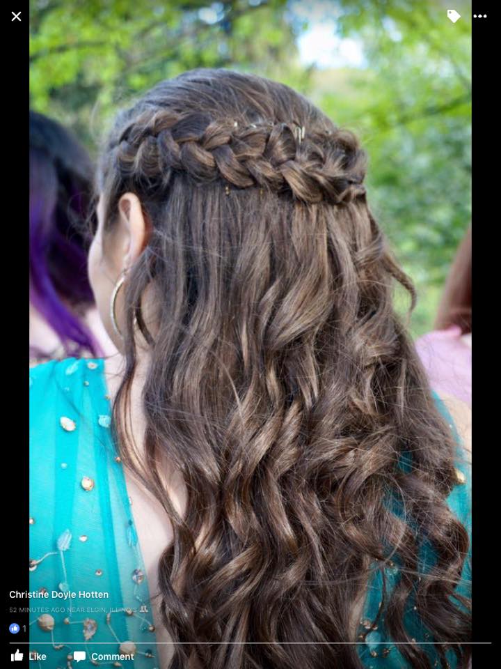 A woman with long hair is wearing a braided hairstyle.