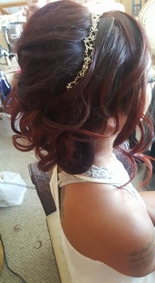 A woman with red hair is wearing a white dress and a headband.