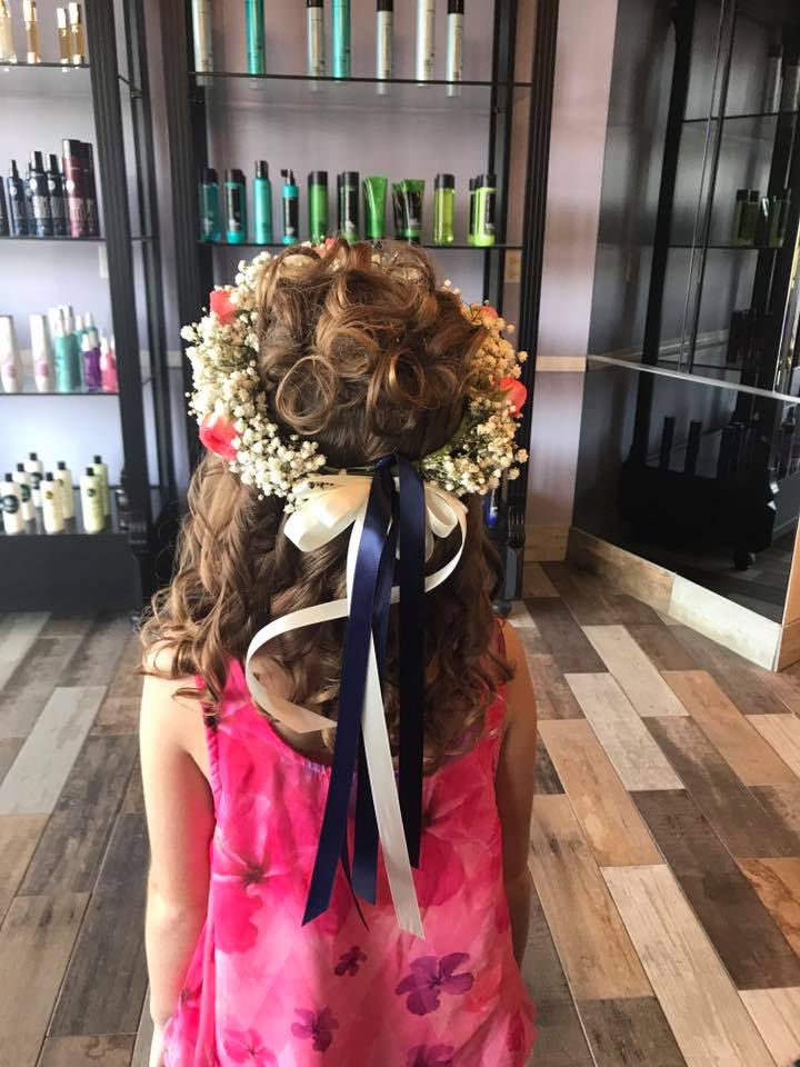A little girl is wearing a flower crown in her hair.
