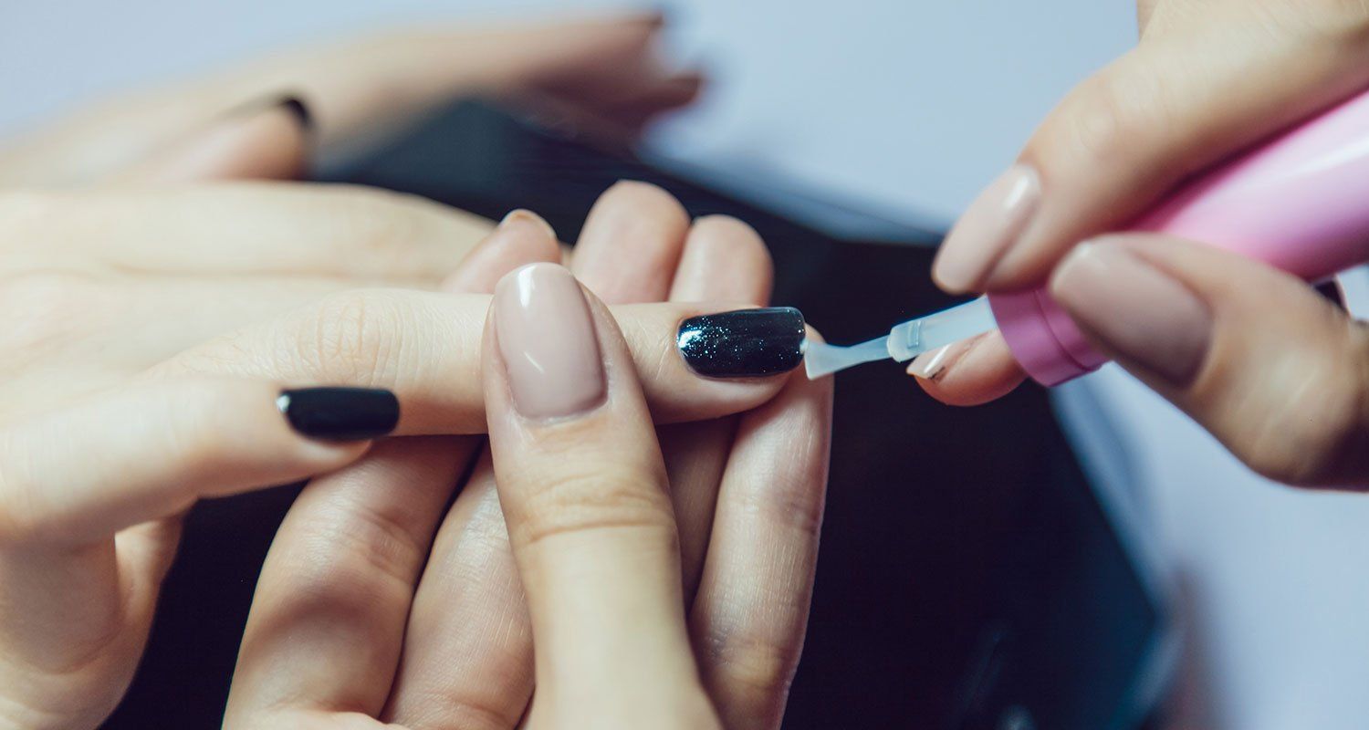 A woman is getting her nails done at a nail salon.