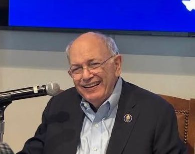 Martin Frost wearing glasses and a suit and tie