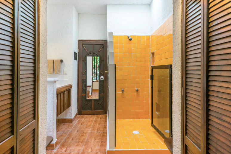 A bathroom with a walk in shower , sink and mirror.