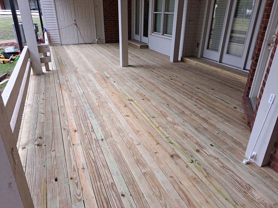 A wooden deck is being built on the side of a house.