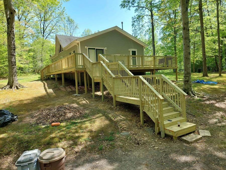 A house with a wooden deck and stairs in front of it.