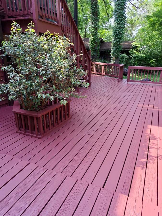A red deck with a potted plant on it