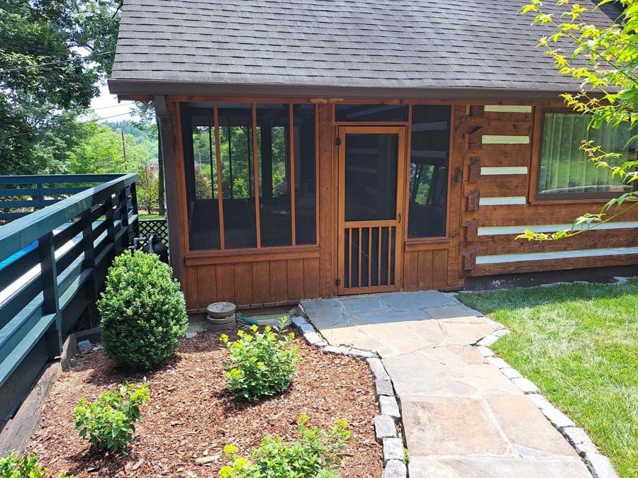 A screened in porch with a walkway leading to it