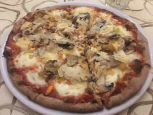Pizza con funghi e formaggio su un piatto bianco