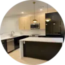 A kitchen with stainless steel appliances and black cabinets in a circle.