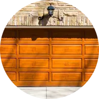 A wooden garage door is sitting in front of a brick wall.
