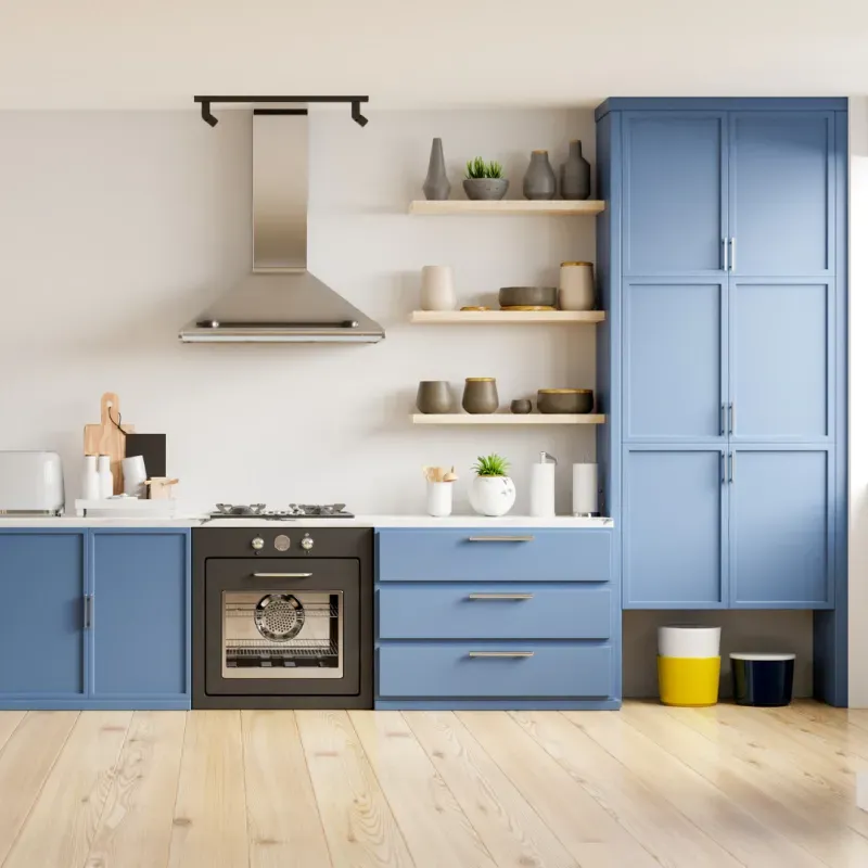 A kitchen with blue cabinets and a stove top oven