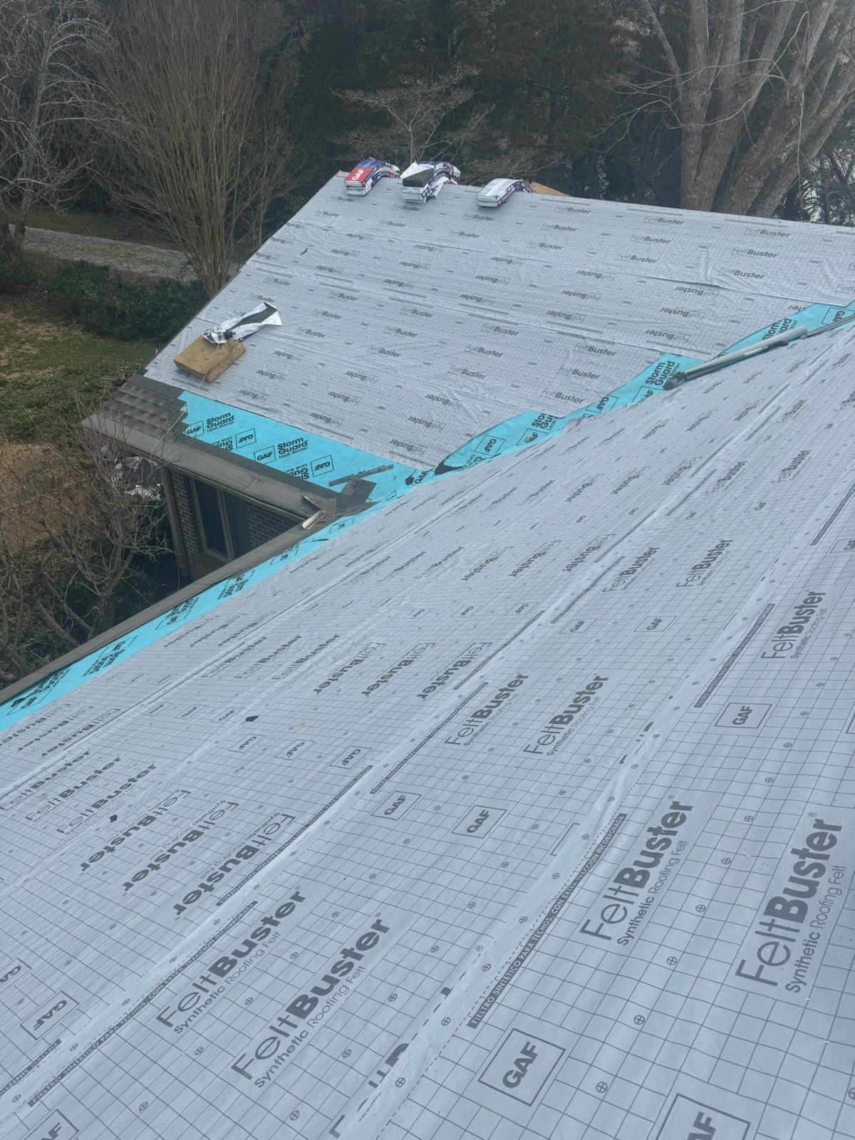 A roof with a lot of shingles on it is being installed.