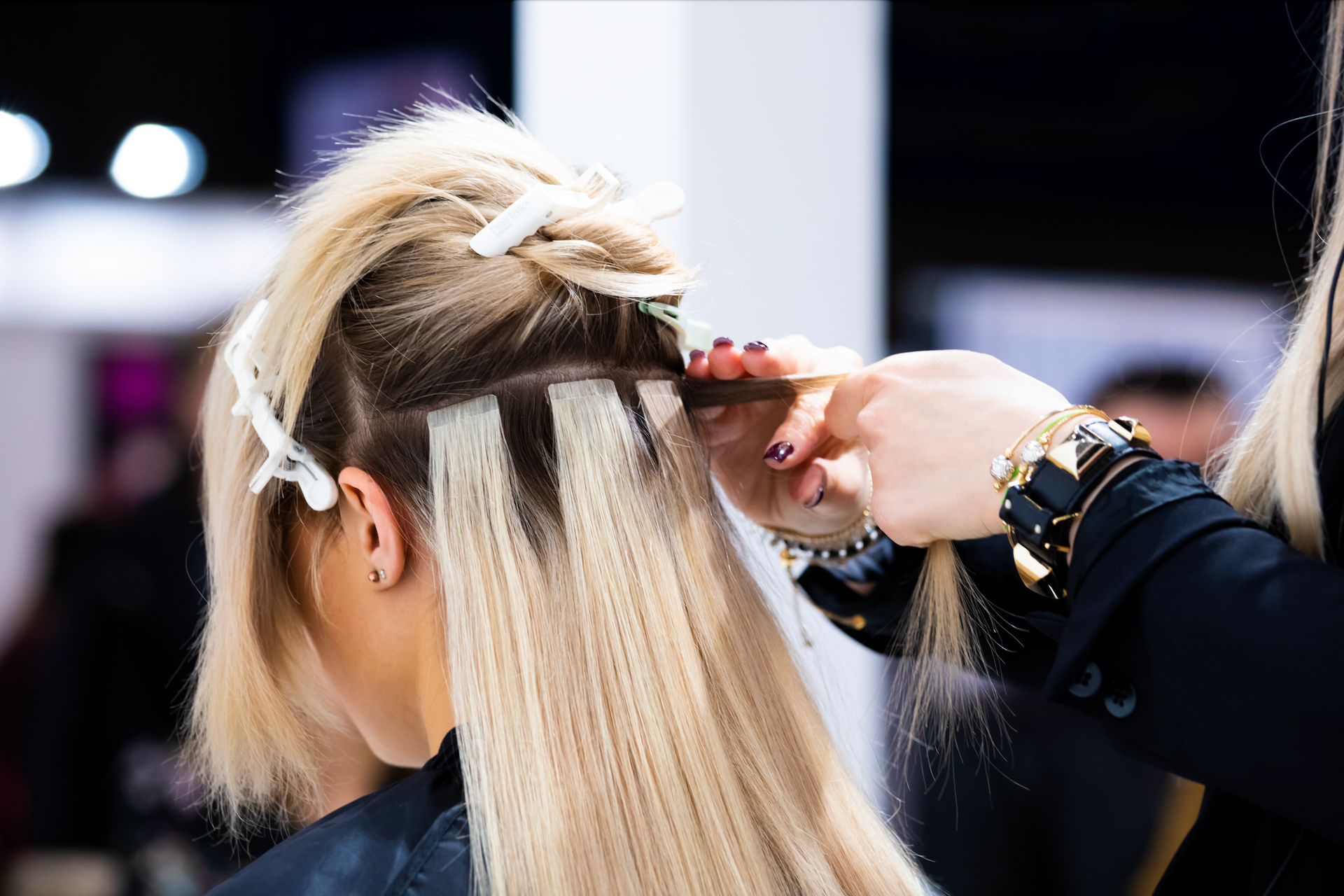 A woman is getting her hair done by a hairdresser in a salon.